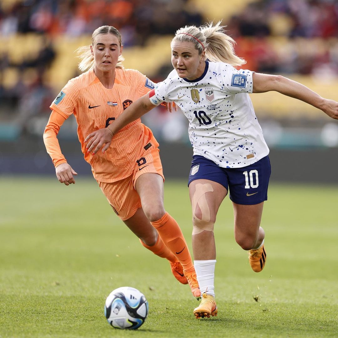 Lindsay Rohan, camisa 10 dos Estados Unidos, correr com a bola à sua frente, enquanto uma jogadora da Holanda tenta alcançá-la