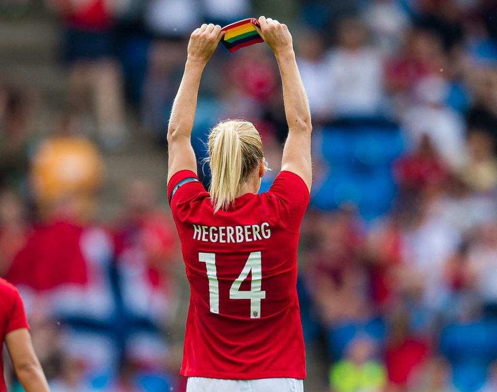 Ada Hegerberg ergue a braçadeira de capitã com as cores do arco-íris durante partida da seleção da Noruega de futebol feminino